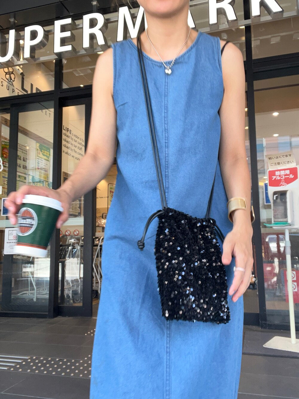 ブルー系のワンピース、ピンク系のトートバッグ、ブラウン系のサンダルを着用したレディースの夏コーディネートの2枚目の写真