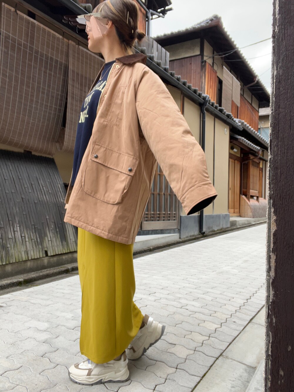 ブルー系のスウェット、イエロー系のスカート、ベージュ系のブルゾンを着用したレディースの冬コーディネートの2枚目の写真