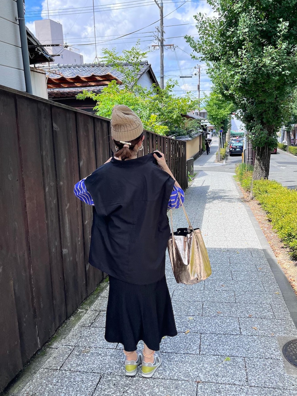 パープル系のスニーカー、ブルー系のTシャツ/カットソー、ゴールド系のショルダーバッグを着用したレディースの秋コーディネートの3枚目の写真