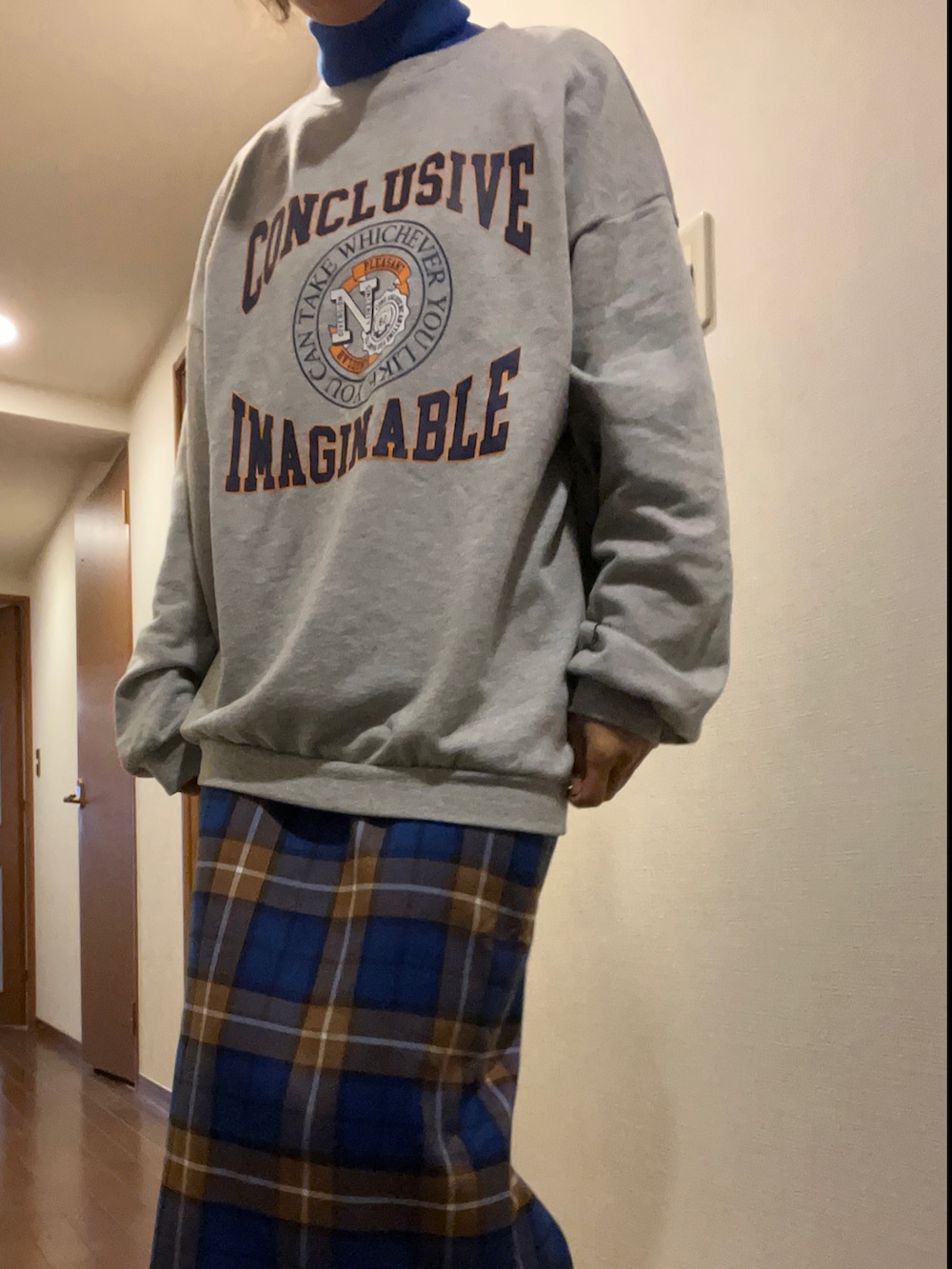 グレー系のスウェット、ブラック系のスカート、ブラック系のトートバッグを着用したレディースの秋コーディネートの3枚目の写真