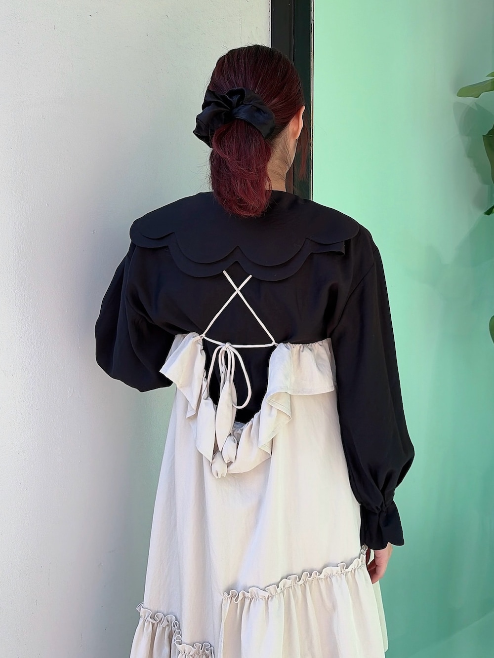 ベージュ系のワンピース、ブラック系のシャツ/ブラウス、ホワイト系のスニーカーを着用したレディースの冬コーディネートの4枚目の写真