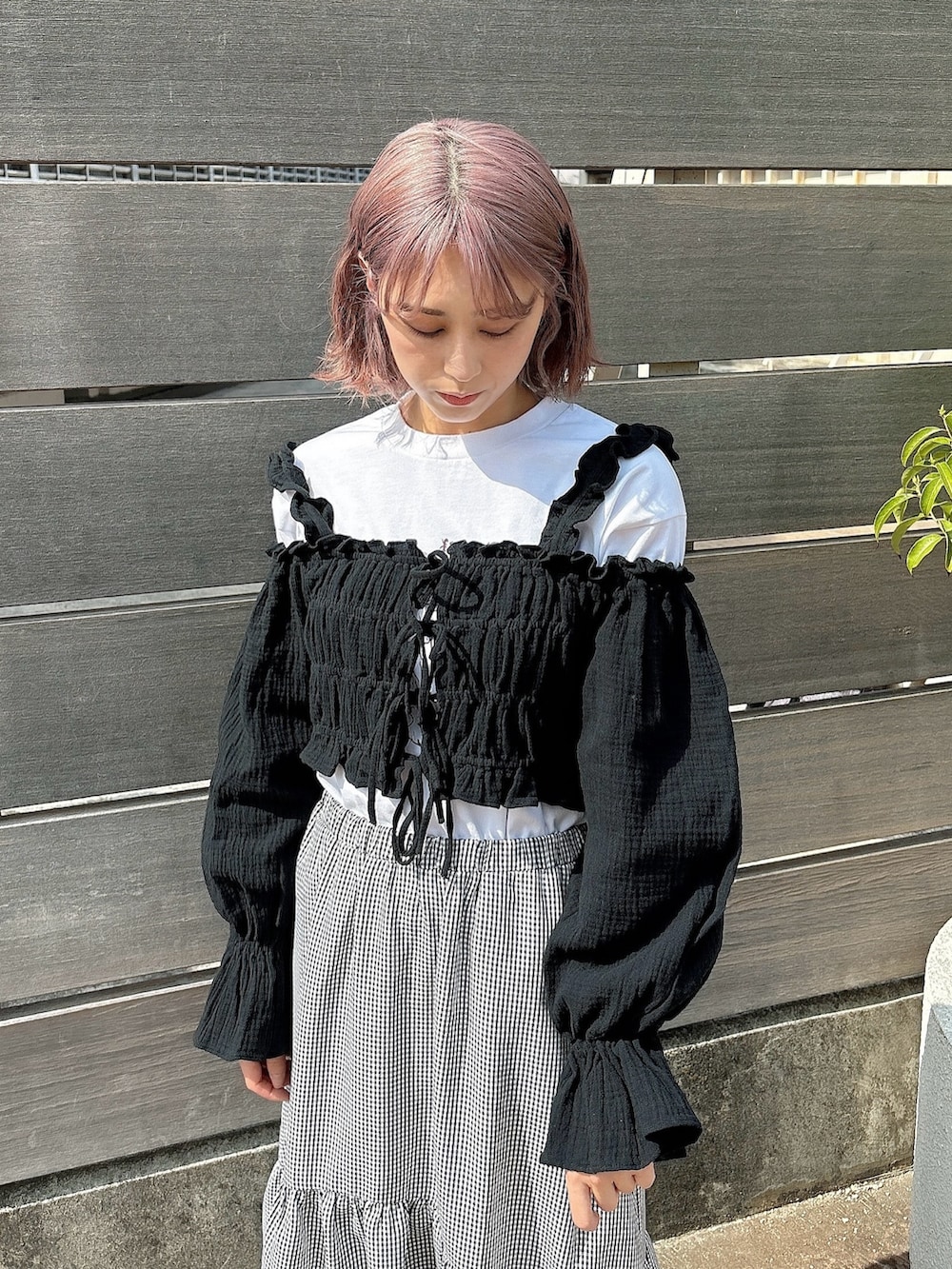 ブラック系のスカート、ホワイト系のTシャツ/カットソー、ブラック系のシャツ/ブラウスを着用したレディースの春コーディネートの3枚目の写真