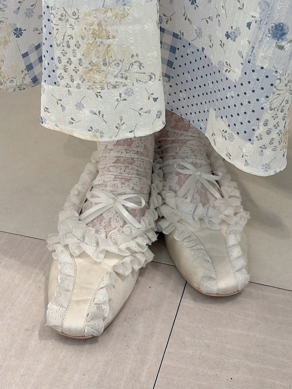 グレー系のパーカー、ブルー系のスカート、ホワイト系のバレエシューズを着用したレディースの冬コーディネートの7枚目の写真