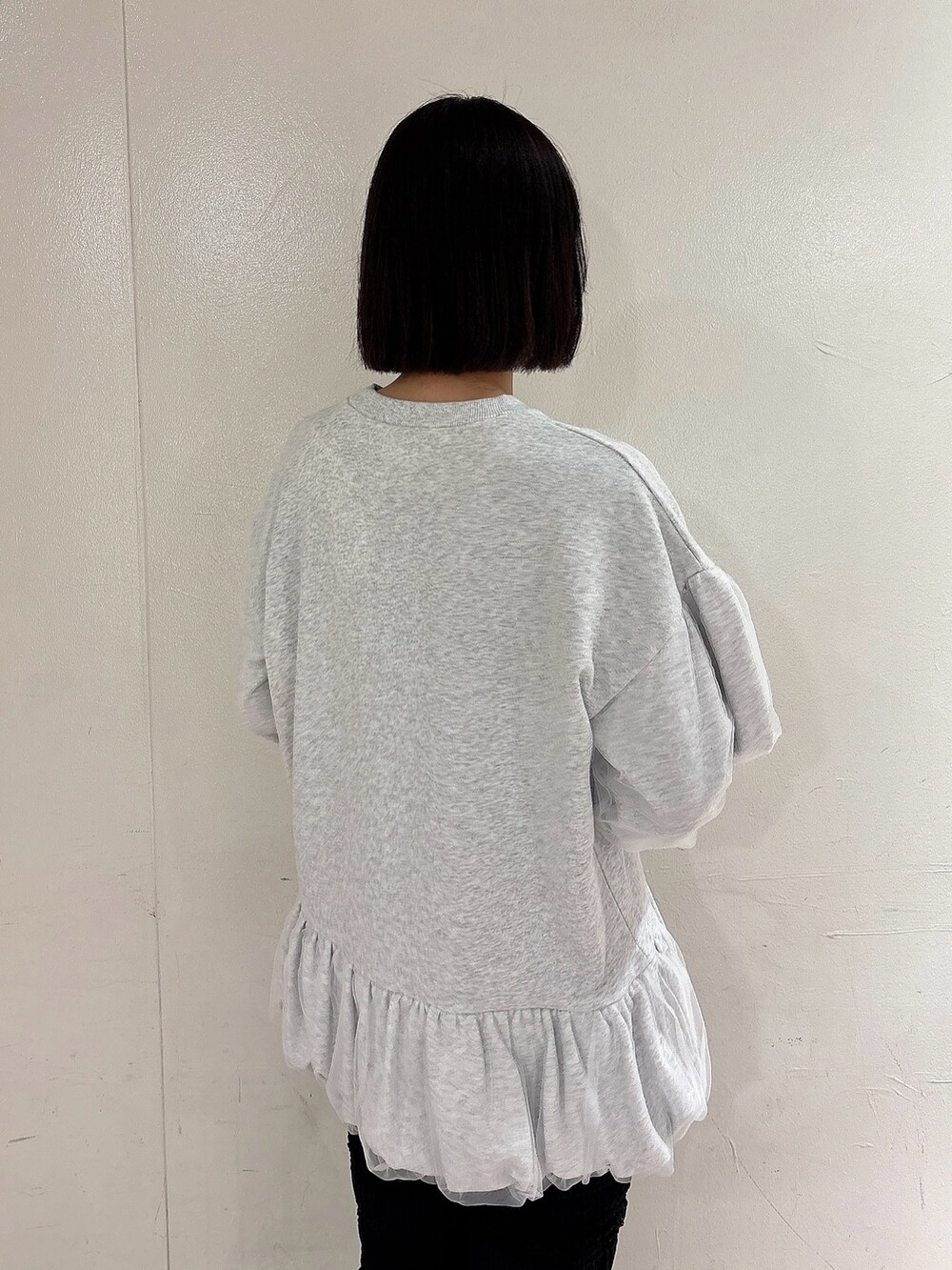 グレー系のスウェット、ブラック系のその他パンツ、ホワイト系のスニーカーを着用したレディースの冬コーディネートの3枚目の写真