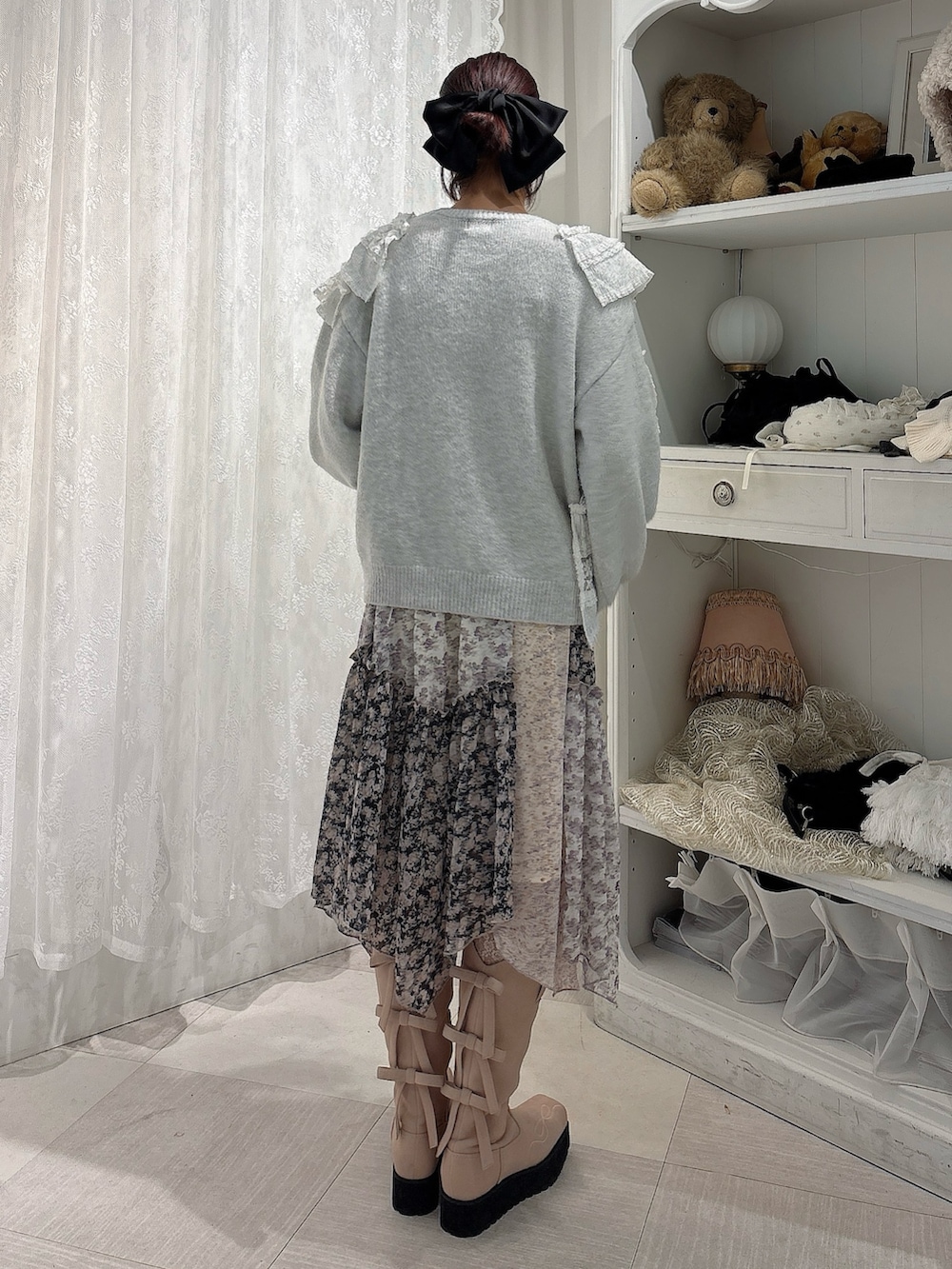 グレー系のニット/セーター、ブラック系のスカート、ピンク系のブーツを着用したレディースの秋コーディネートの2枚目の写真