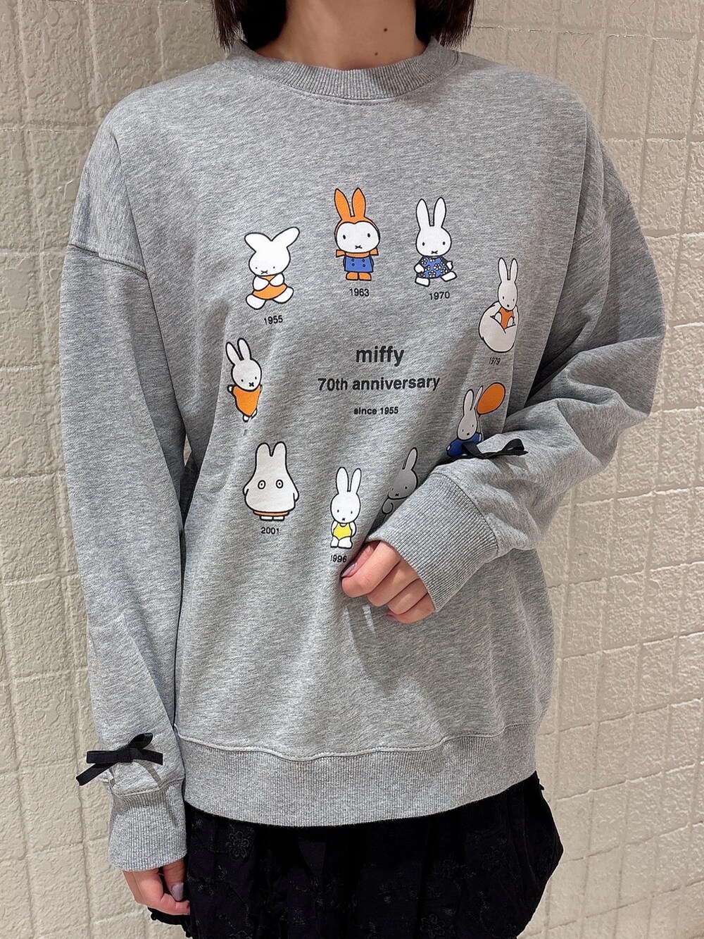 グレー系のスウェット、ブラック系のスカート、ホワイト系のその他パンツを着用したレディースの冬コーディネートの5枚目の写真