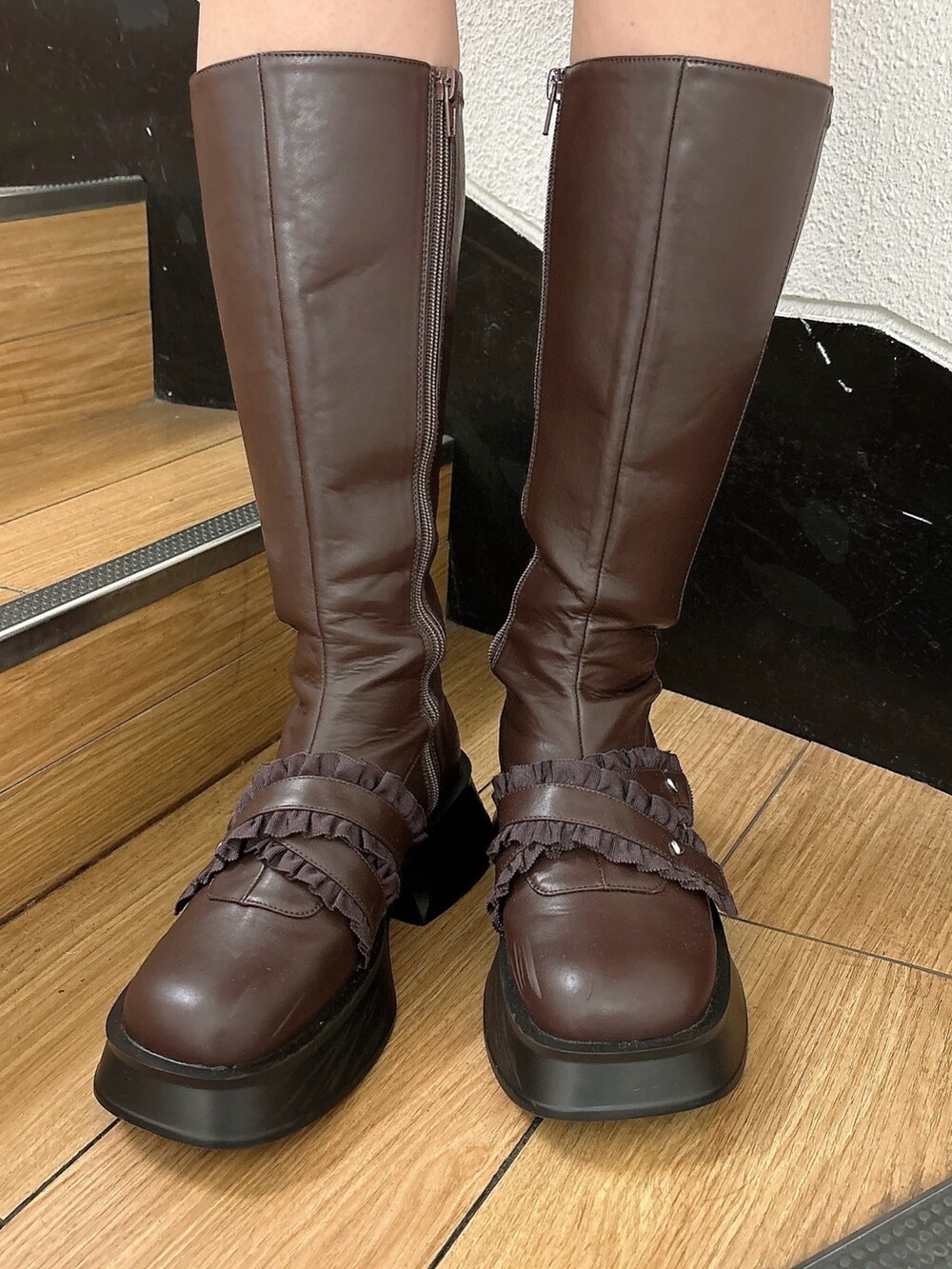 ピンク系のスカート、ブラウン系のブーツ、ブラック系のダウンジャケット/コートを着用したレディースの冬コーディネートの6枚目の写真