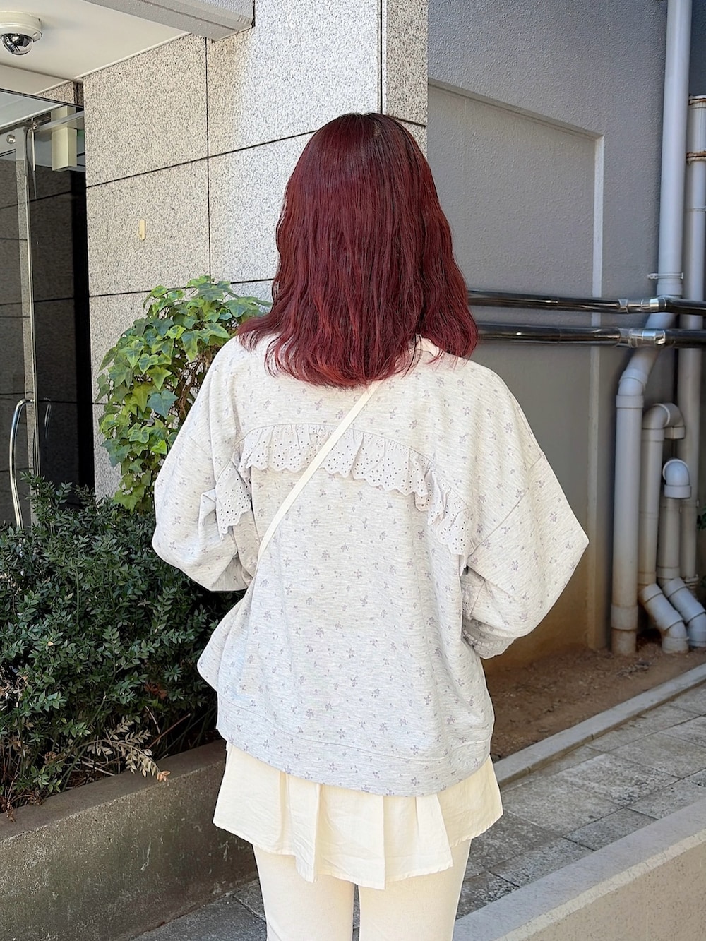 グレー系のスウェット、ホワイト系のショルダーバッグ、ホワイト系のスウェットパンツを着用したレディースの冬コーディネートの4枚目の写真