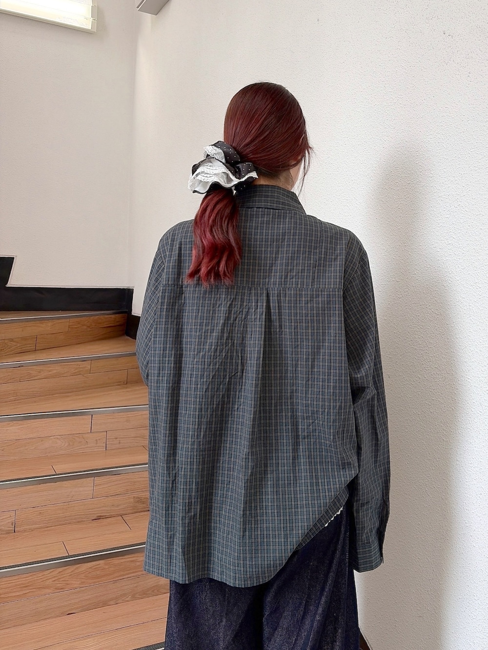 グリーン系のシャツ/ブラウス、ブルー系のデニムパンツ、ブラック系のスニーカーを着用したレディースの秋コーディネートの5枚目の写真