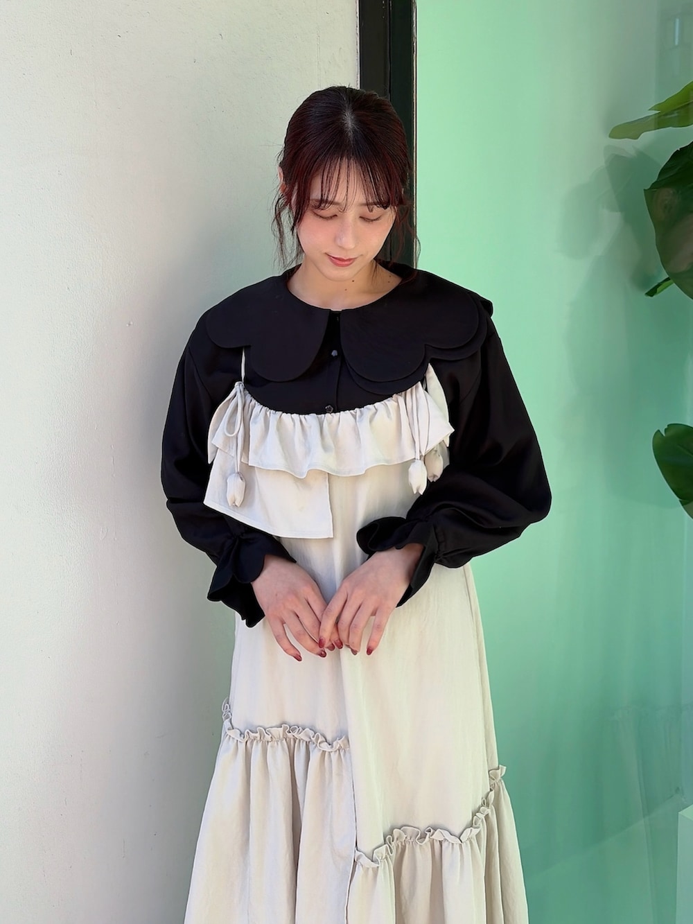 ベージュ系のワンピース、ブラック系のシャツ/ブラウス、ホワイト系のスニーカーを着用したレディースの冬コーディネートの3枚目の写真