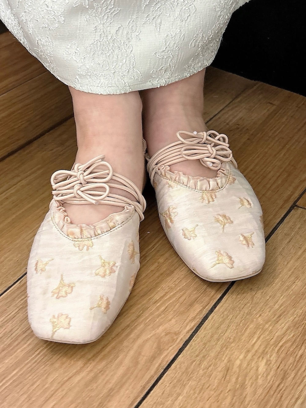 グリーン系のワンピース、ゴールド系のバレエシューズ、ホワイト系のTシャツ/カットソーを着用したレディースの冬コーディネートの4枚目の写真