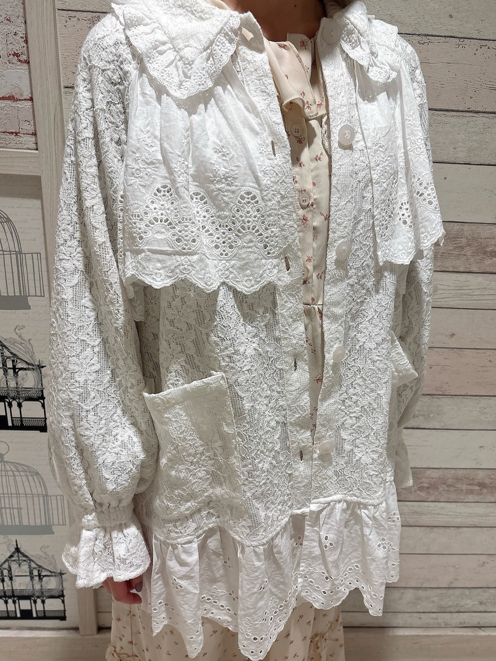 ホワイト系のテーラードジャケット、ホワイト系のワンピース、ホワイト系のスニーカーを着用したレディースの冬コーディネートの5枚目の写真