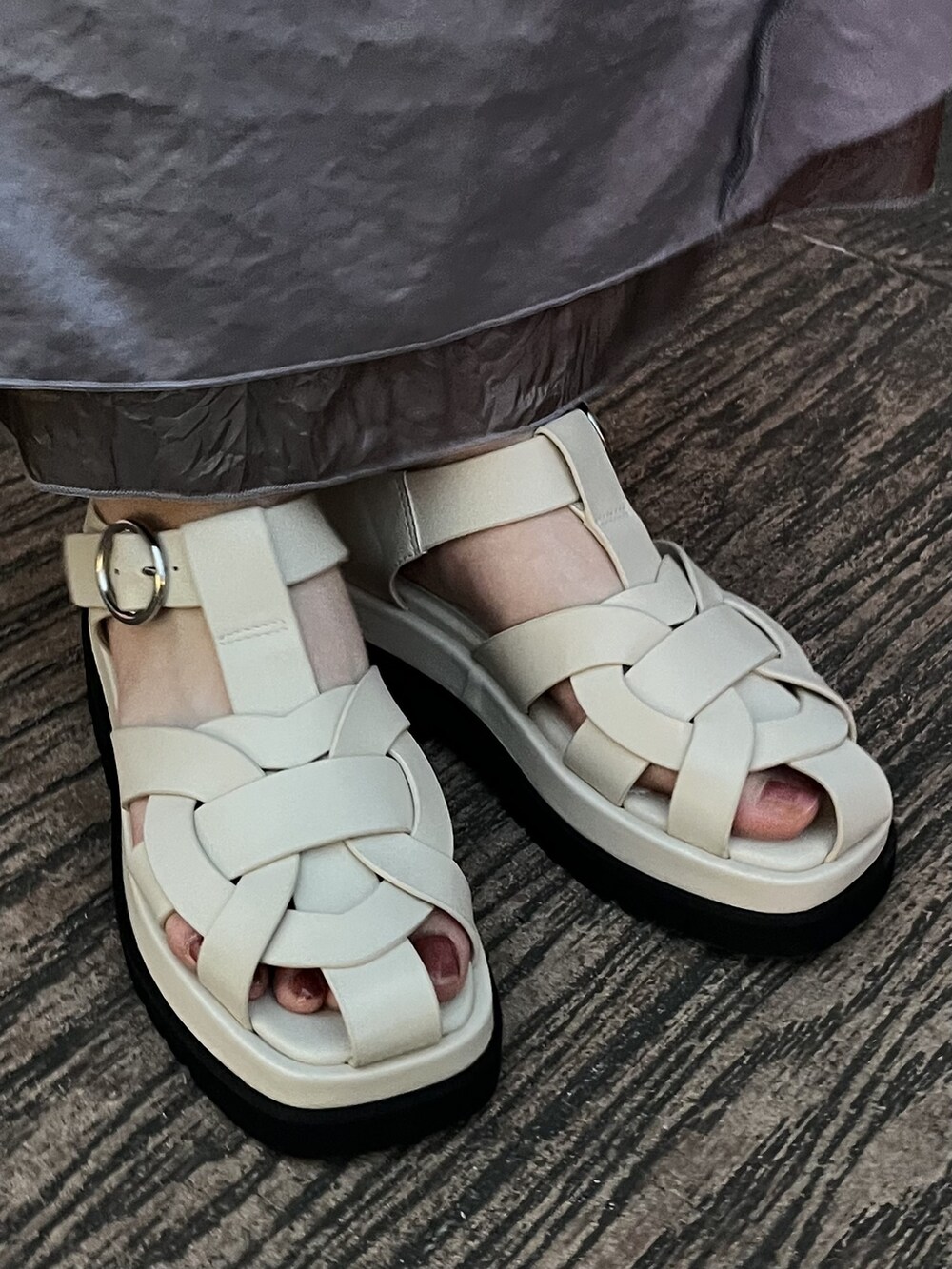 ホワイト系のハンドバッグ、ホワイト系のサンダル、ブルー系のワンピースを着用したレディースの夏コーディネートの3枚目の写真