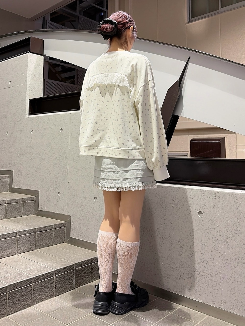 ホワイト系のスウェット、ブルー系のスカート、ブラック系のスニーカーを着用したレディースの冬コーディネートの2枚目の写真