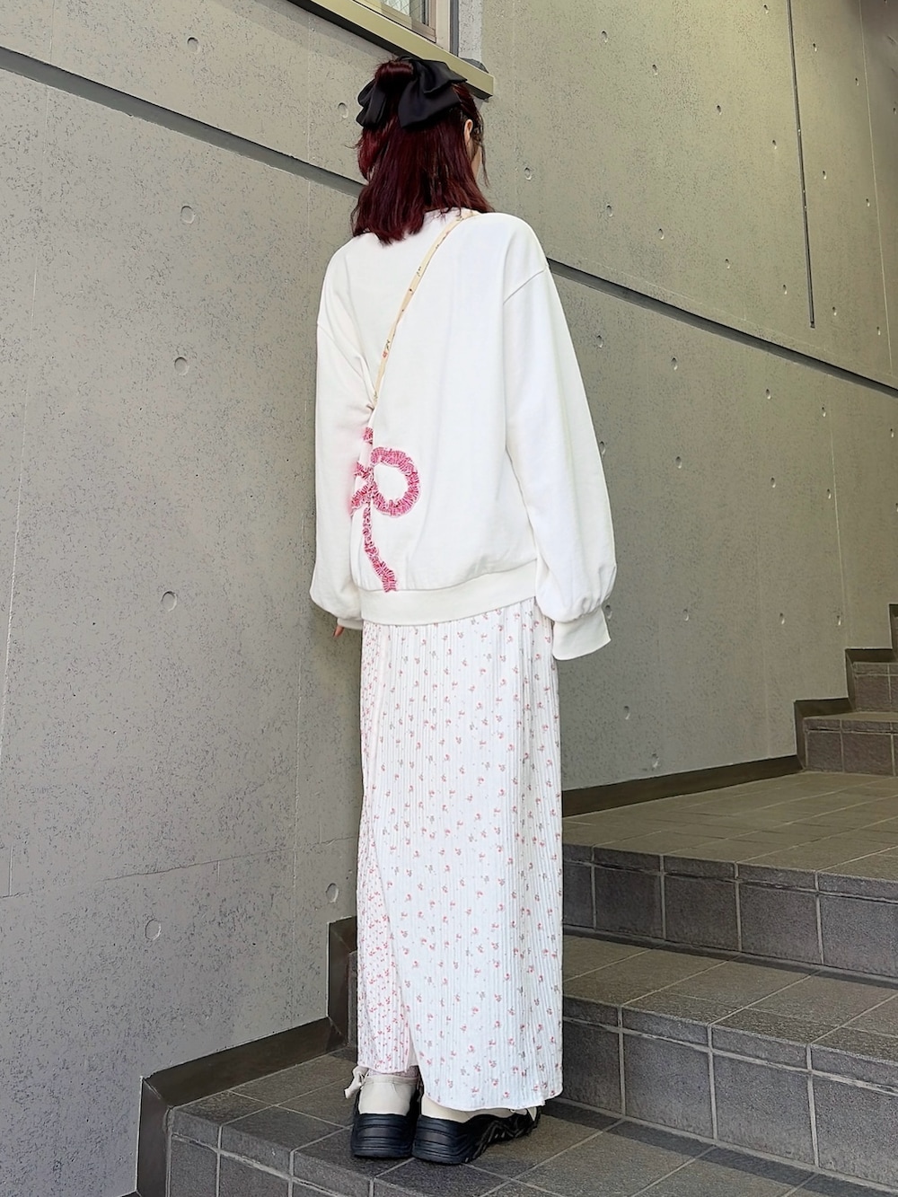 ホワイト系のスウェット、ホワイト系のショルダーバッグ、ピンク系のスカートを着用したレディースの冬コーディネートの2枚目の写真