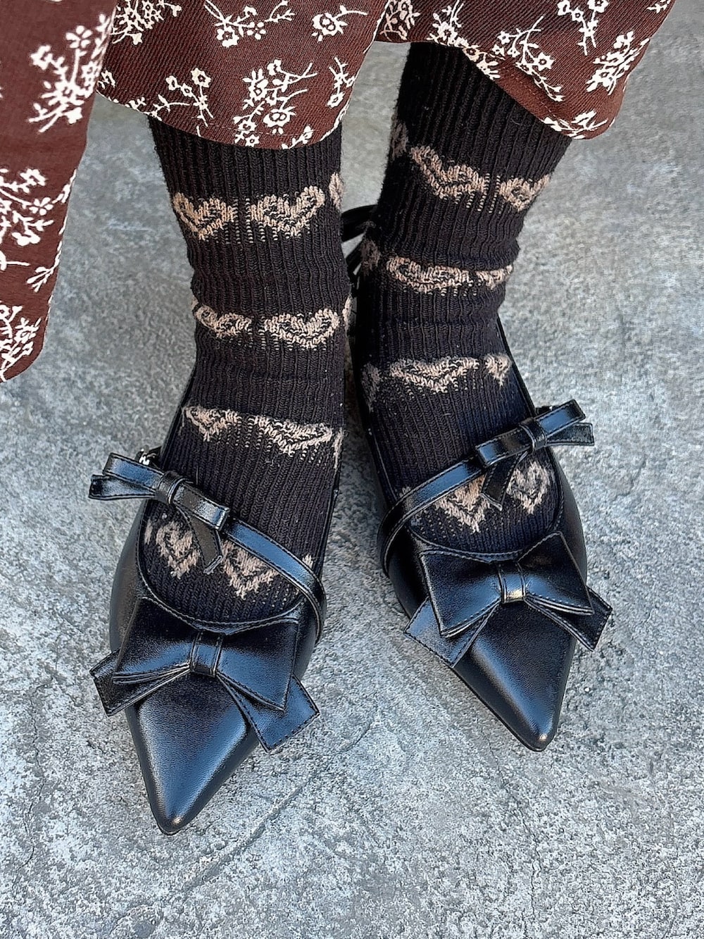 ブラウン系のワンピース、ブラック系のパンプス、ピンク系のカーディガン/ボレロを着用したレディースの冬コーディネートの9枚目の写真