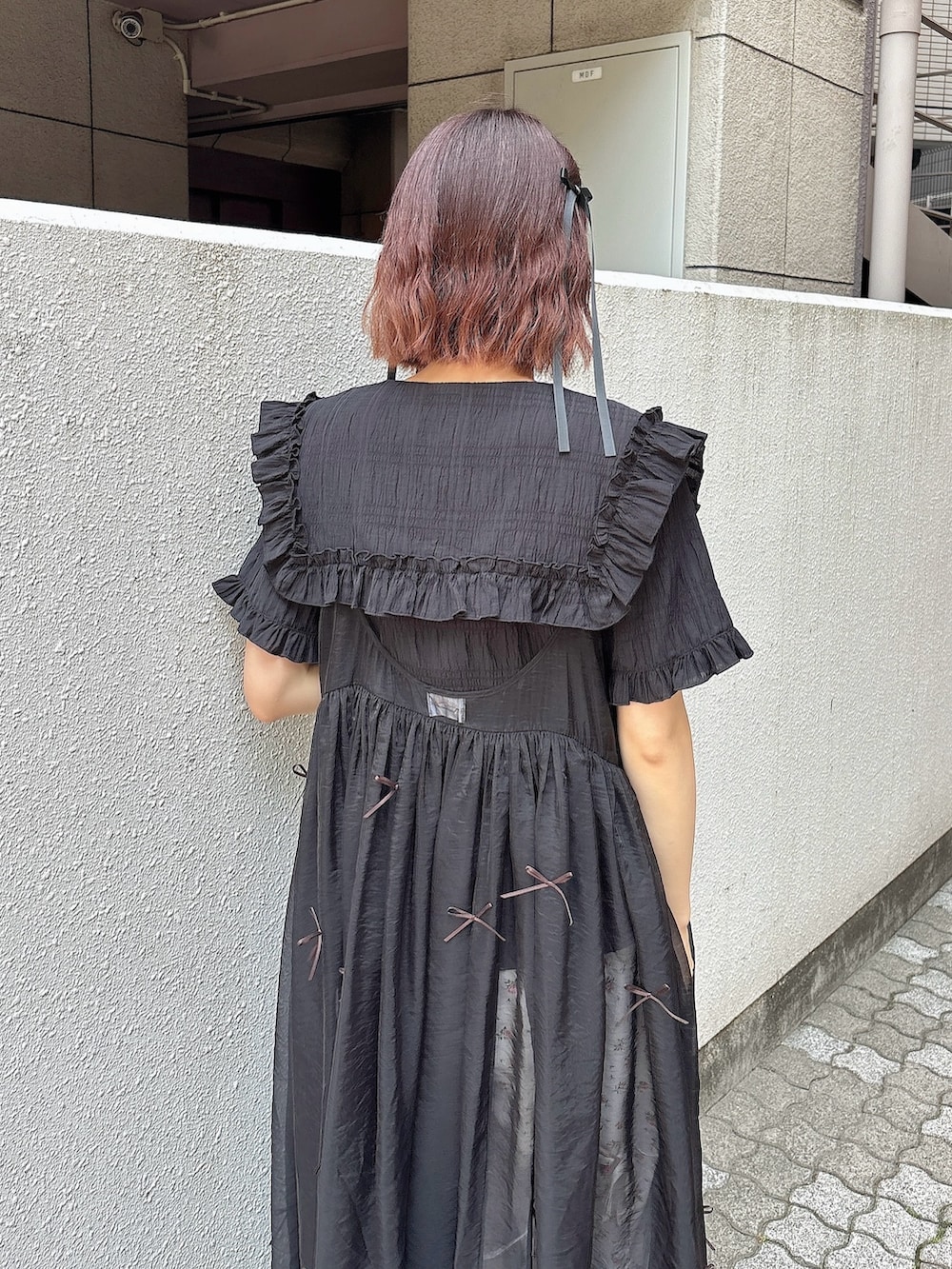 ブラック系のシャツ/ブラウス、ブラック系のワンピース、ホワイト系のスラックスを着用したレディースの春コーディネートの4枚目の写真