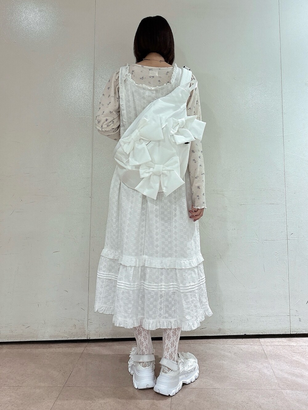 パープル系のTシャツ/カットソー、ホワイト系のワンピース、ホワイト系のショルダーバッグを着用したレディースの春コーディネートの2枚目の写真
