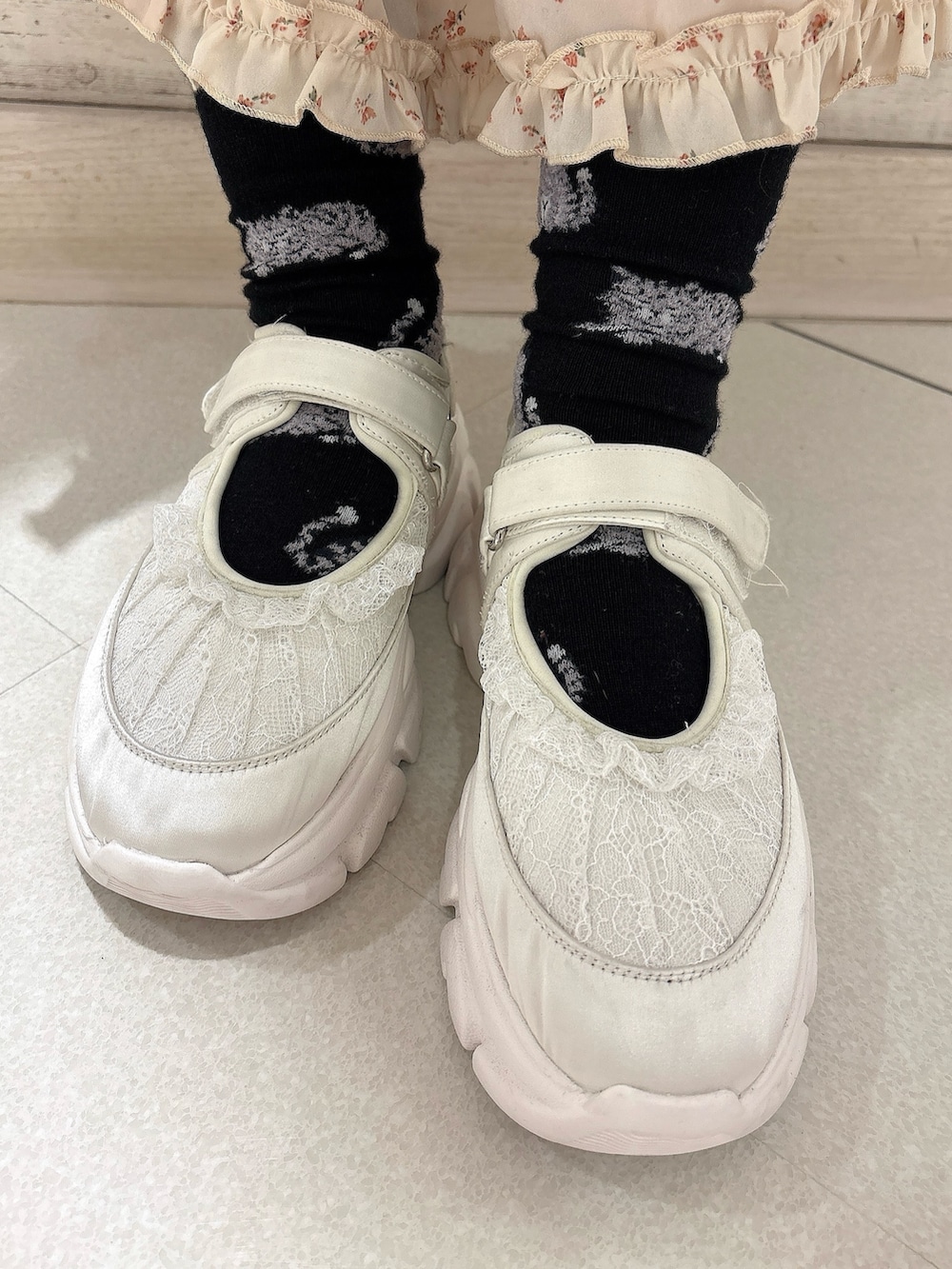 ホワイト系のテーラードジャケット、ホワイト系のワンピース、ホワイト系のスニーカーを着用したレディースの冬コーディネートの6枚目の写真