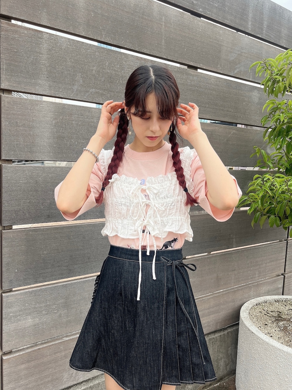 ピンク系のサンダル、ブラック系のデニムスカート、ピンク系のTシャツ/カットソーを着用したレディースの夏コーディネートの2枚目の写真