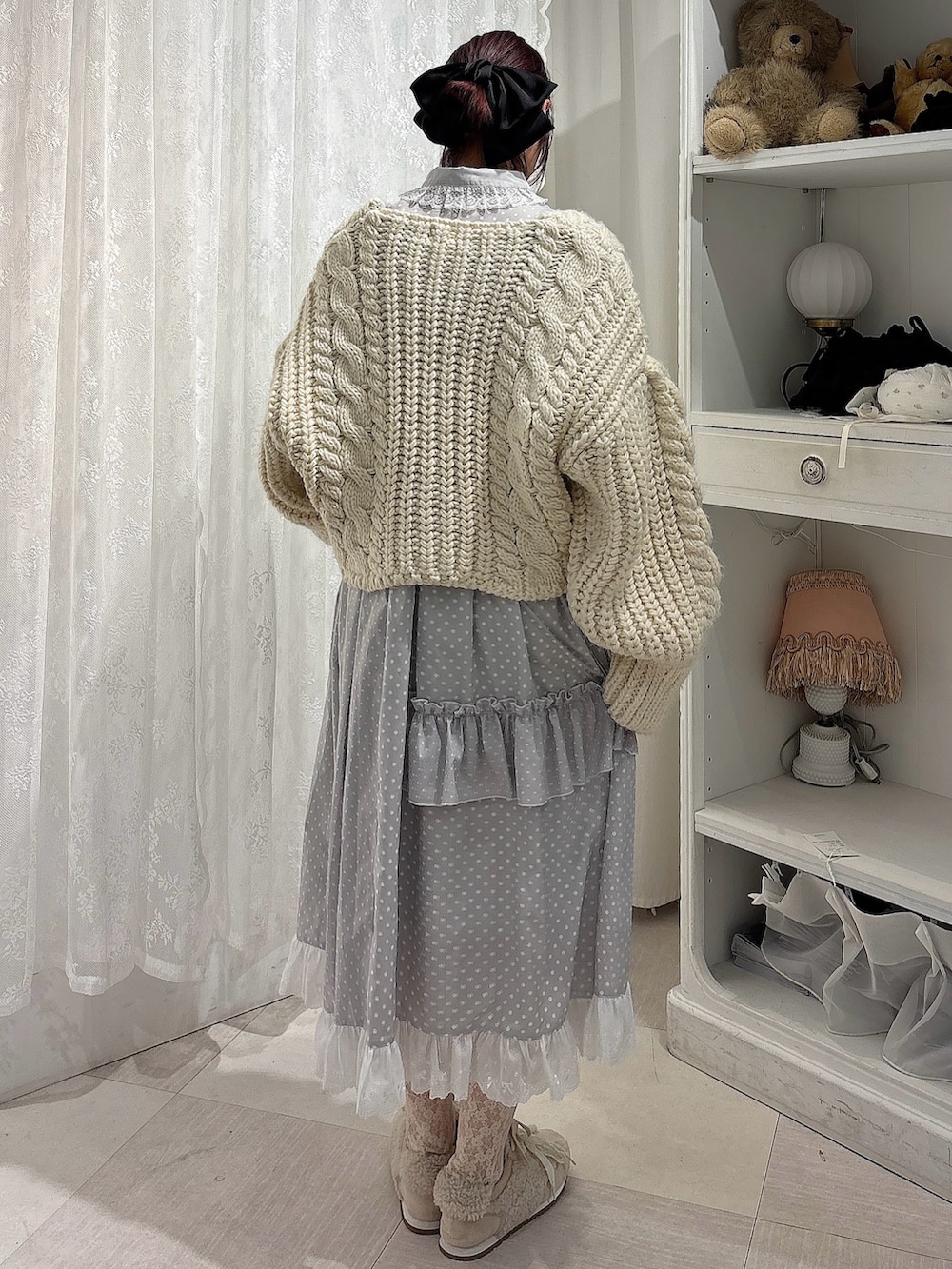 ホワイト系のカーディガン/ボレロ、グレー系のワンピース、ピンク系のスニーカーを着用したレディースの秋コーディネートの2枚目の写真