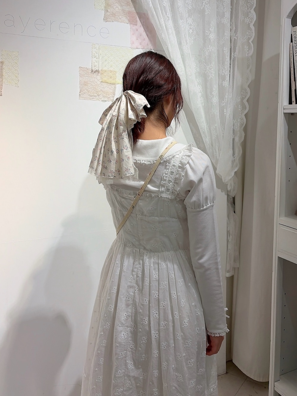 ホワイト系のポロシャツ、ホワイト系のワンピース、ホワイト系のショルダーバッグを着用したレディースの冬コーディネートの4枚目の写真