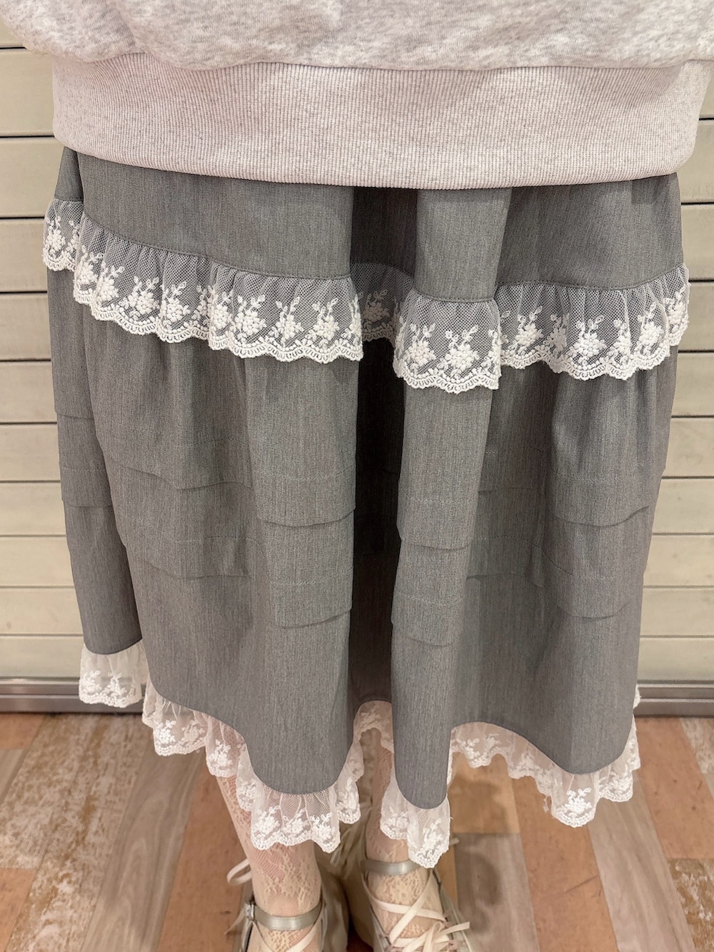 ブルー系のニット/セーター、グレー系のスウェット、グレー系のスカートを着用したレディースの冬コーディネートの5枚目の写真