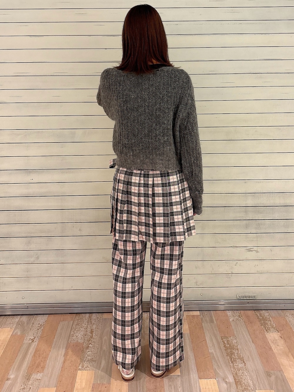 グレー系のニット/セーター、ブラック系のTシャツ/カットソー、ピンク系のスラックスを着用したレディースの秋コーディネートの2枚目の写真