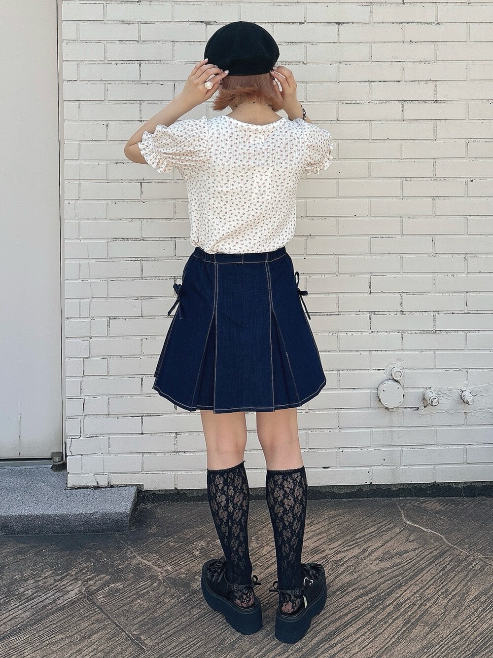 ブルー系のスカート、ブラック系のサンダル、ピンク系のTシャツ/カットソーを着用したレディースの春コーディネートの2枚目の写真