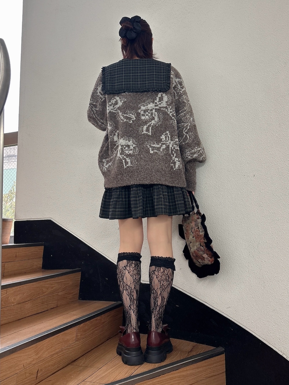 グリーン系のワンピース、ブラウン系のカーディガン/ボレロ、レッド系のローファーを着用したレディースの秋コーディネートの2枚目の写真