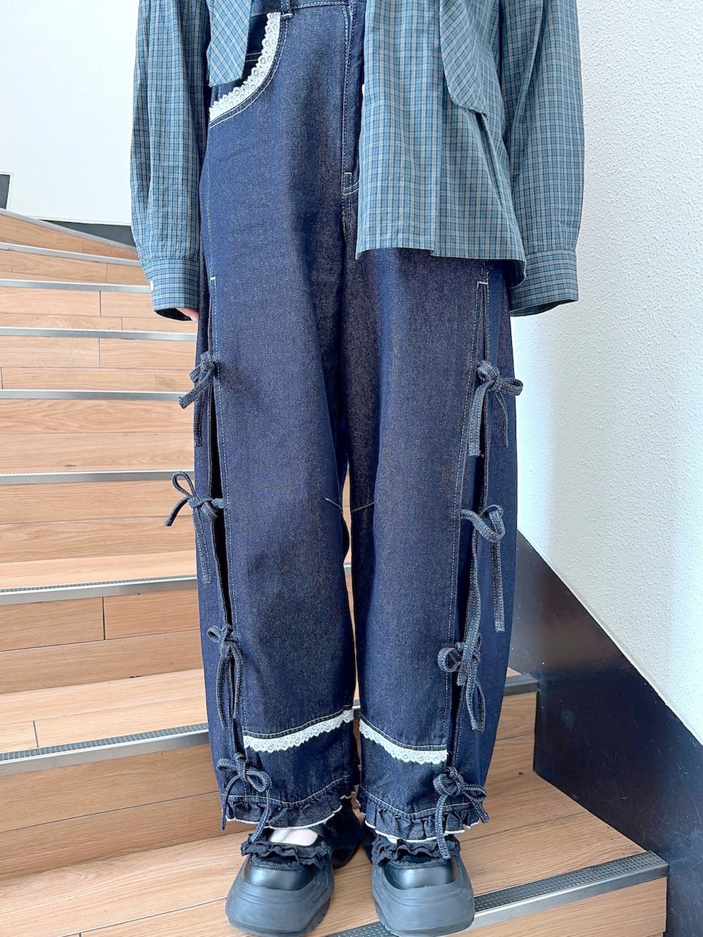 グリーン系のシャツ/ブラウス、ブルー系のデニムパンツ、ブラック系のスニーカーを着用したレディースの秋コーディネートの7枚目の写真