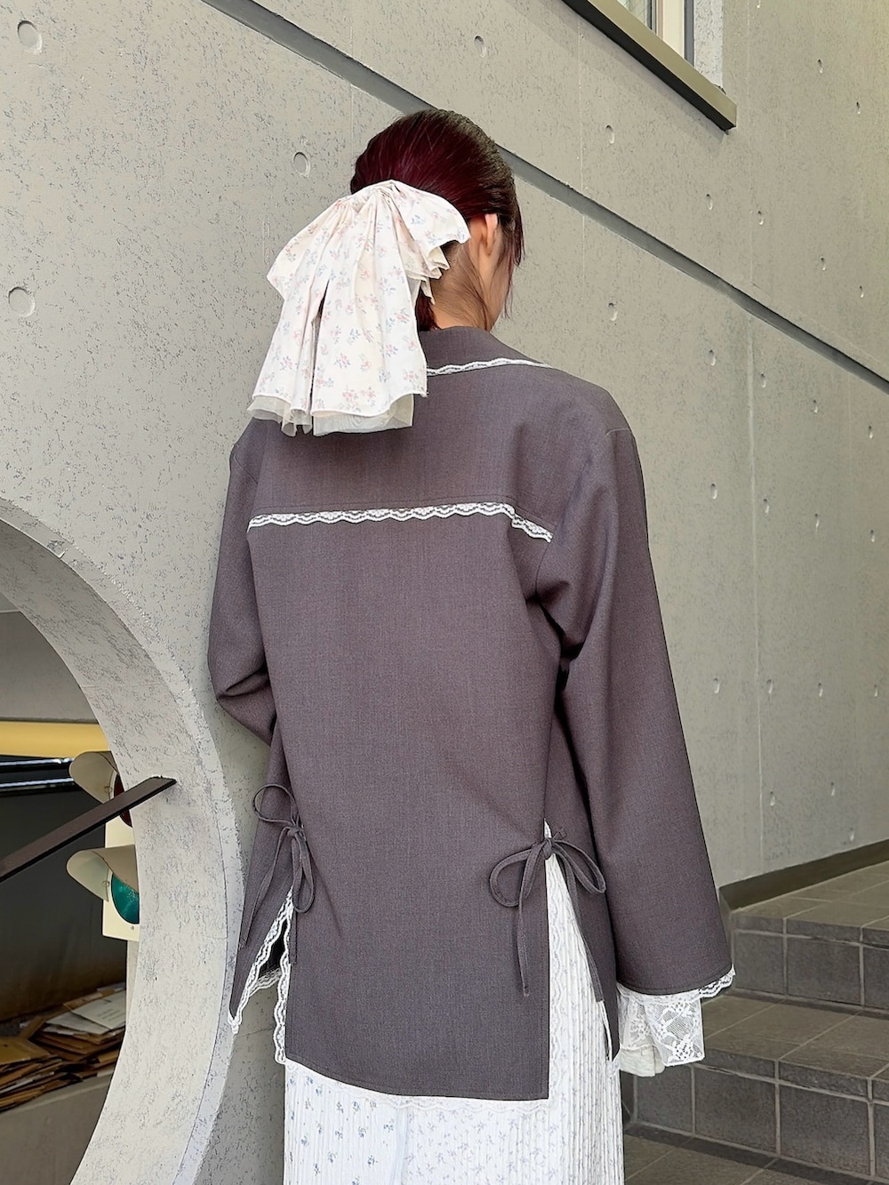 グレー系のテーラードジャケット、グレー系のTシャツ/カットソー、パープル系のスカートを着用したレディースの冬コーディネートの4枚目の写真