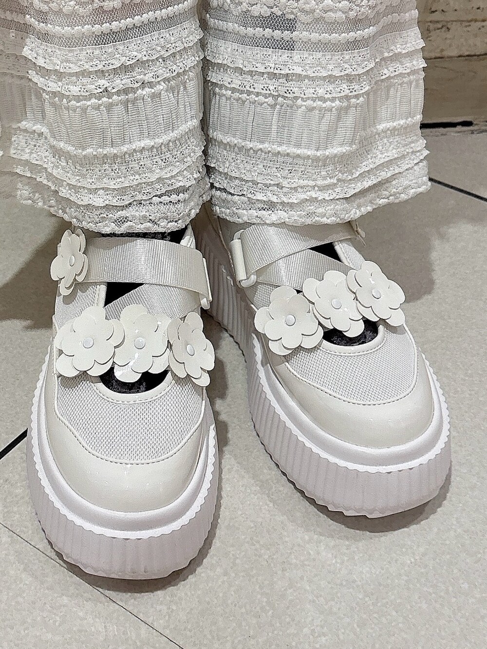 グレー系のスウェット、ブラック系のスカート、ホワイト系のその他パンツを着用したレディースの冬コーディネートの6枚目の写真