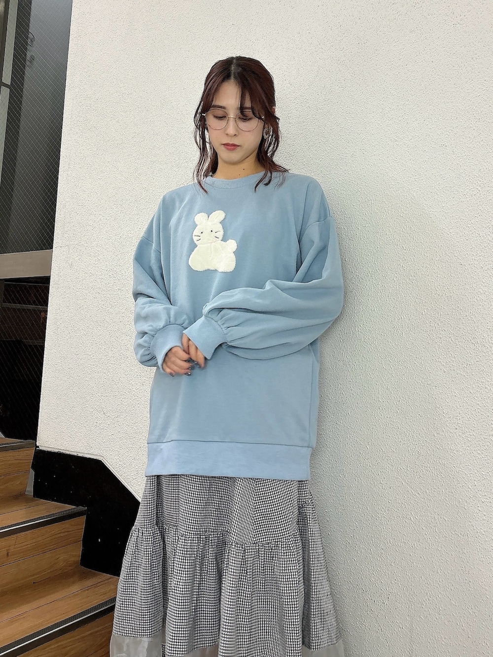 ブルー系のスウェット、ブラック系のスカート、ブラック系のスニーカーを着用したレディースの冬コーディネートの2枚目の写真