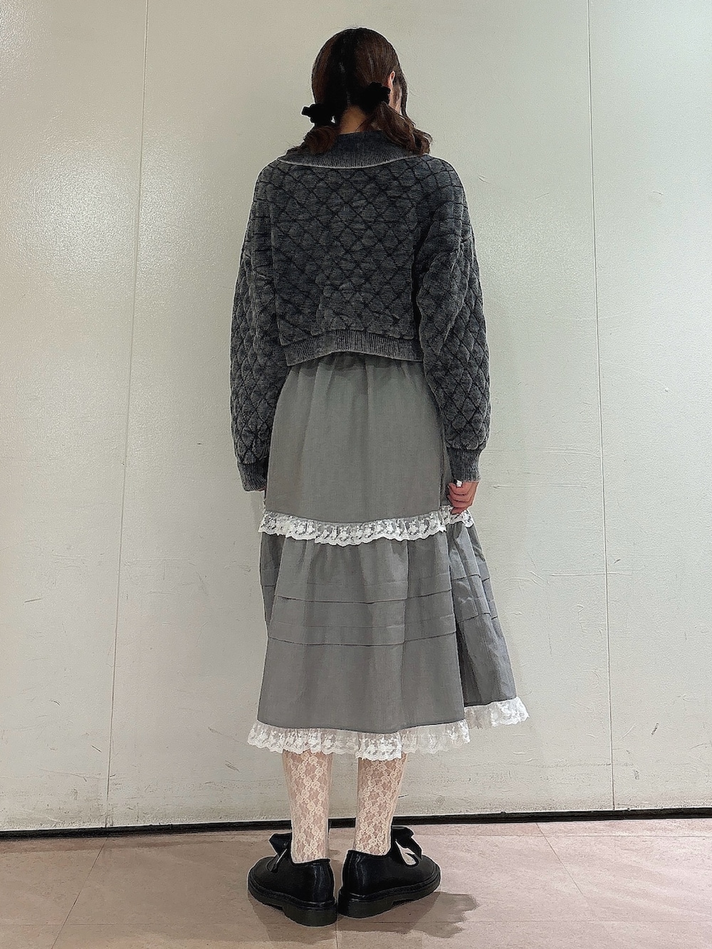 グレー系のカーディガン/ボレロ、グレー系のスカート、ブラック系のバレエシューズを着用したレディースの秋コーディネートの2枚目の写真