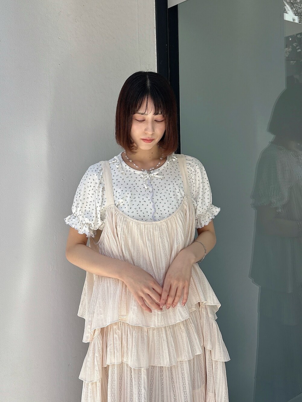 ホワイト系のワンピース、ブルー系のTシャツ/カットソー、ホワイト系のサンダルを着用したレディースの春コーディネートの3枚目の写真