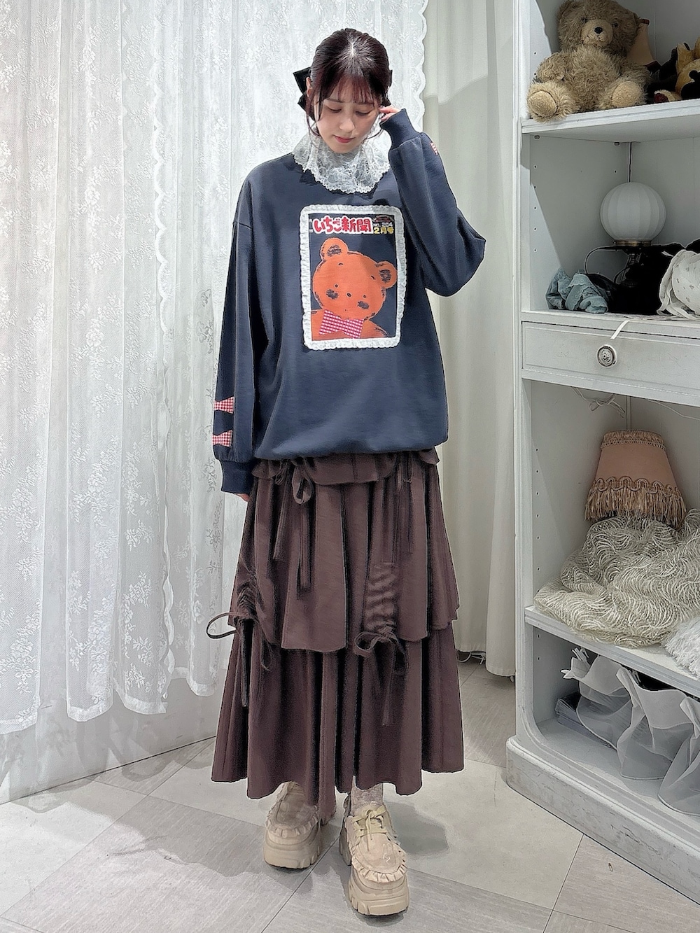 グレー系のスウェット、ブラウン系のトートバッグ、ブラウン系のスカートを着用したレディースの秋コーディネートの2枚目の写真