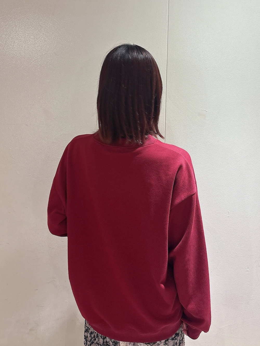 レッド系のスウェット、ブラック系のスカート、ブラウン系のブーツを着用したレディースの秋コーディネートの4枚目の写真