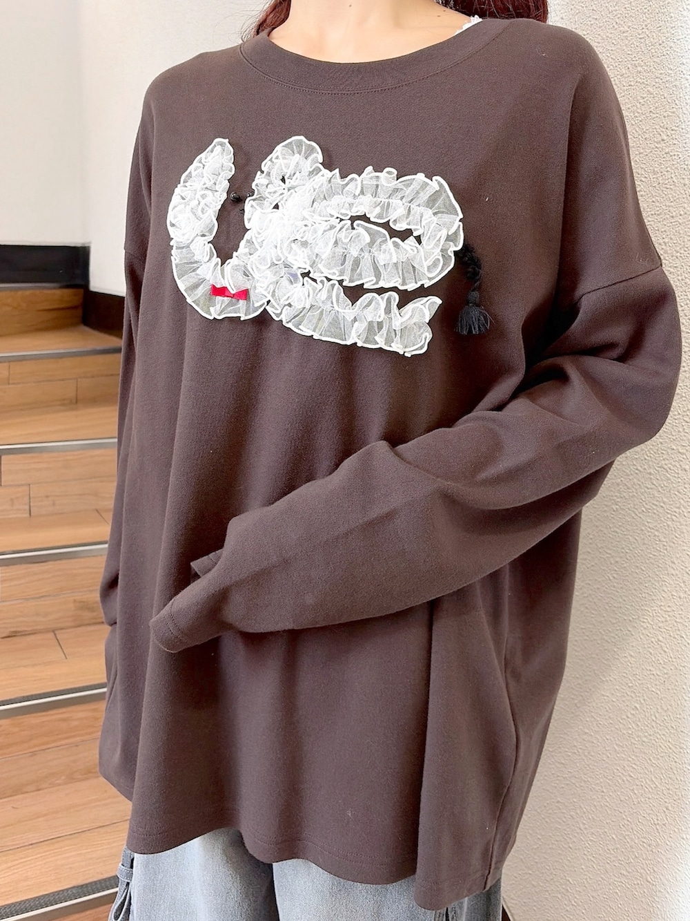 グリーン系のミリタリージャケット、ブラウン系のTシャツ/カットソー、グレー系のデニムパンツを着用したレディースの秋コーディネートの7枚目の写真