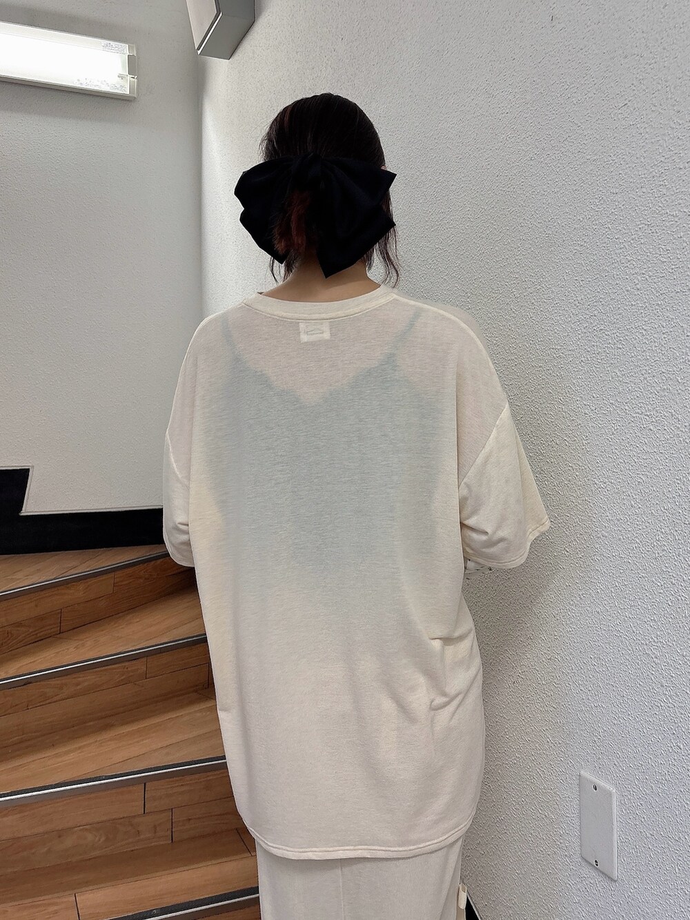 ホワイト系のTシャツ/カットソー、ホワイト系のスカート、ブラウン系のスニーカーを着用したレディースの夏コーディネートの4枚目の写真