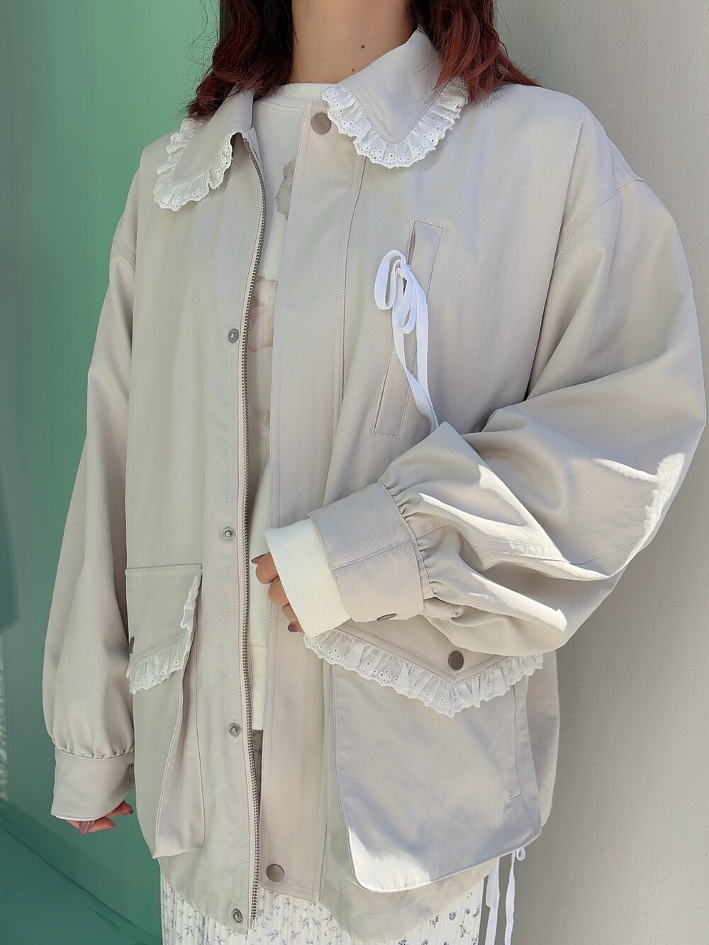 ホワイト系のブルゾン、ホワイト系のスウェット、パープル系のスカートを着用したレディースの冬コーディネートの5枚目の写真