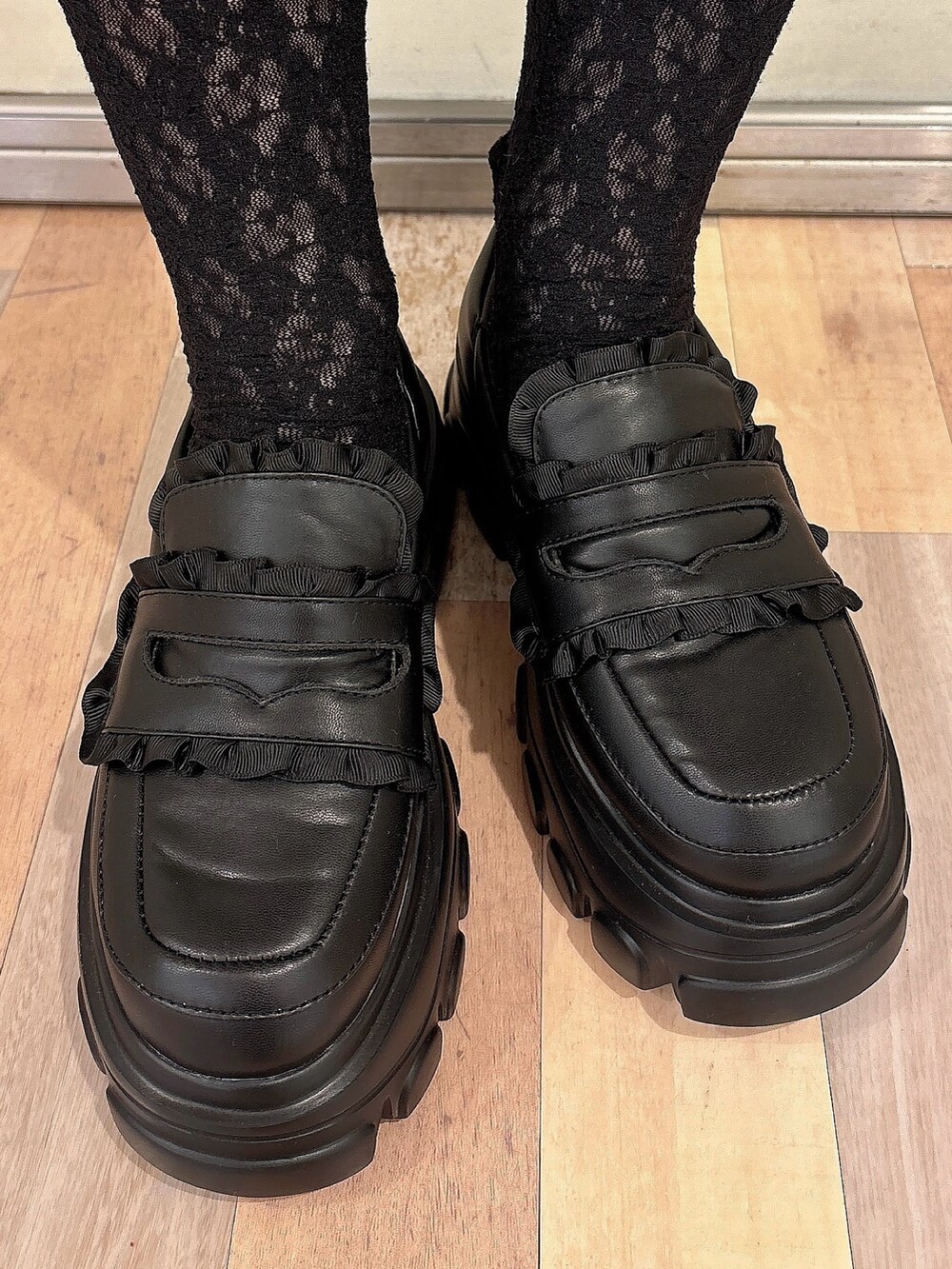 グレー系のスウェット、ブラック系のスカート、ブラック系のローファーを着用したレディースの秋コーディネートの6枚目の写真