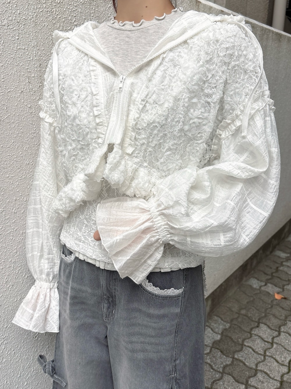 ホワイト系のブルゾン、グレー系のTシャツ/カットソー、グレー系のデニムパンツを着用したレディースの秋コーディネートの5枚目の写真