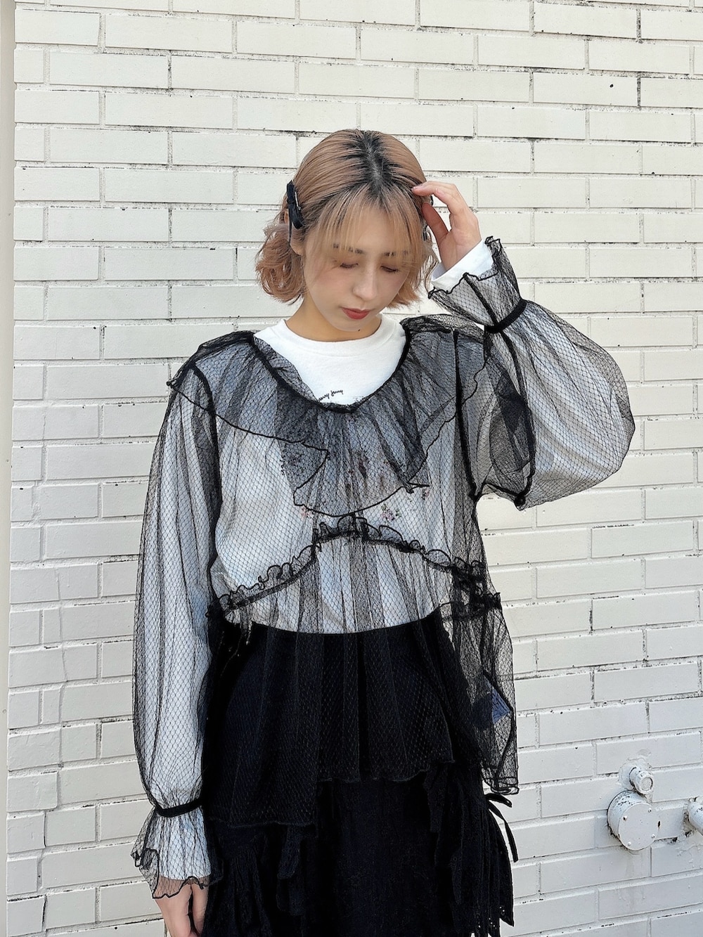 ブラック系のスカート、ブラック系のスニーカー、ホワイト系のTシャツ/カットソーを着用したレディースの春コーディネートの3枚目の写真
