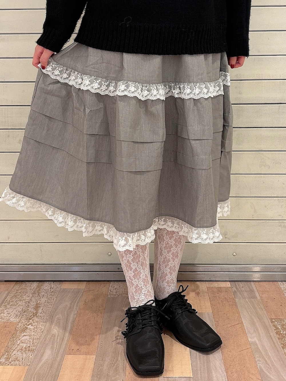 ブラック系のニット/セーター、グレー系のスカート、ブラック系のローファーを着用したレディースの秋コーディネートの6枚目の写真