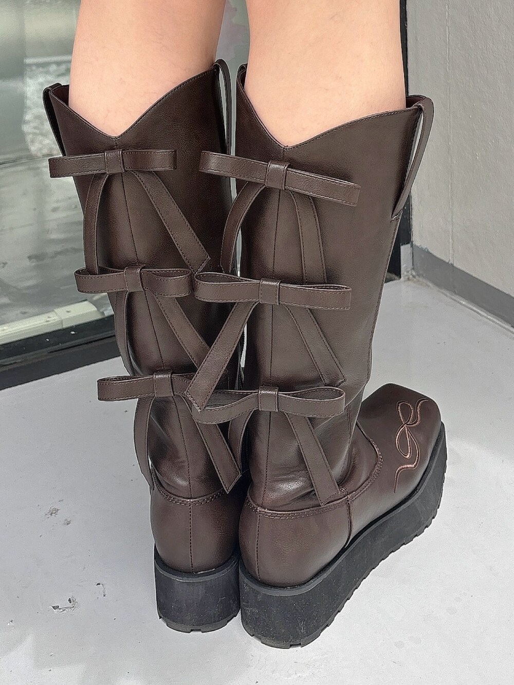 ブラウン系のワンピース、ブラウン系のブーツ、ブラック系のレギンス/スパッツを着用したレディースの夏コーディネートの7枚目の写真