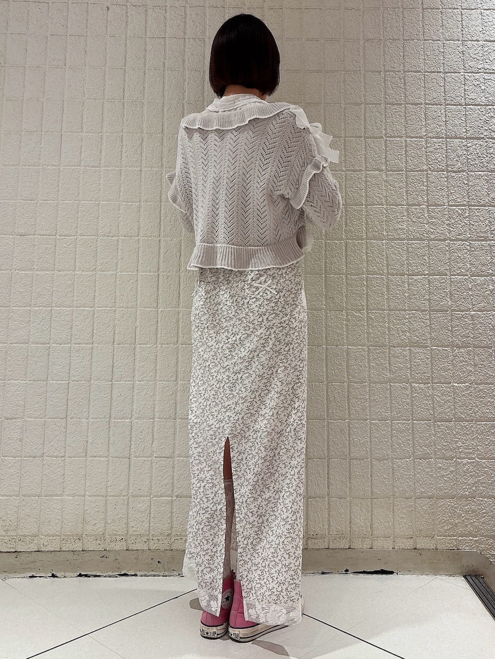ホワイト系のカーディガン/ボレロ、グレー系のカーディガン/ボレロ、ホワイト系のスカートを着用したレディースの冬コーディネートの2枚目の写真