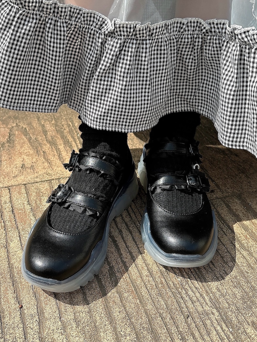 ブラック系のスカート、ホワイト系のTシャツ/カットソー、ブラック系のシャツ/ブラウスを着用したレディースの春コーディネートの8枚目の写真