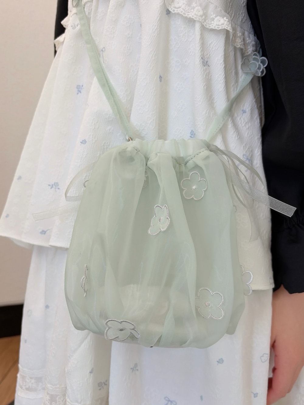 ブラック系のシャツ/ブラウス、グリーン系のハンドバッグ、ホワイト系のワンピースを着用したレディースの冬コーディネートの6枚目の写真