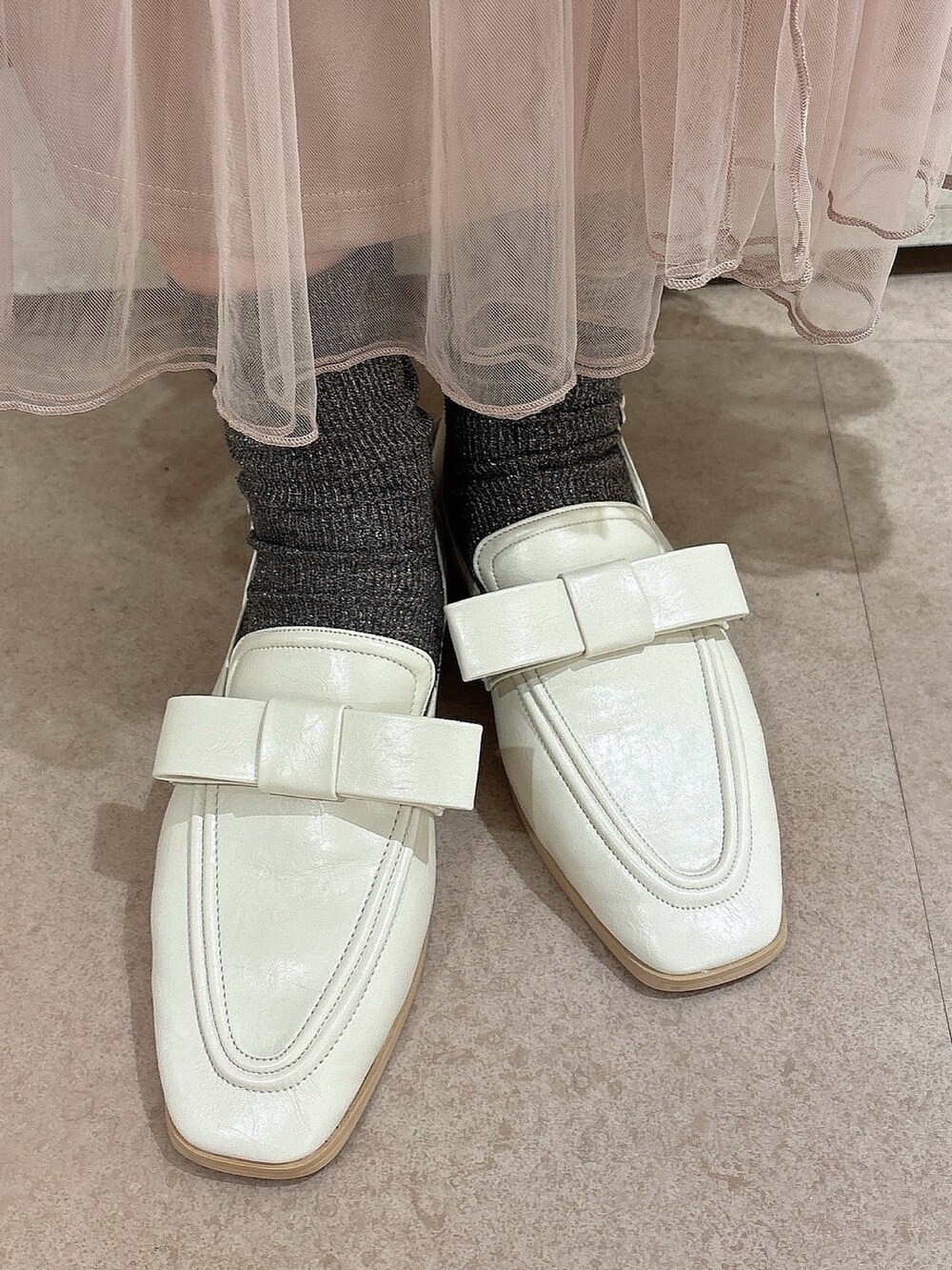 ホワイト系のデニムジャケット、ピンク系のスカート、ホワイト系のローファーを着用したレディースの秋コーディネートの7枚目の写真